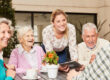Bellevue | Group of happy senior citizens and staff member sitting at table
