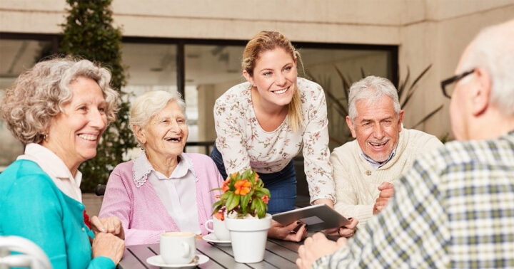 bellevue-senior-living-55-plus-living-vs-independent-living-fb Bellevue | Group of happy senior citizens and staff member sitting at table